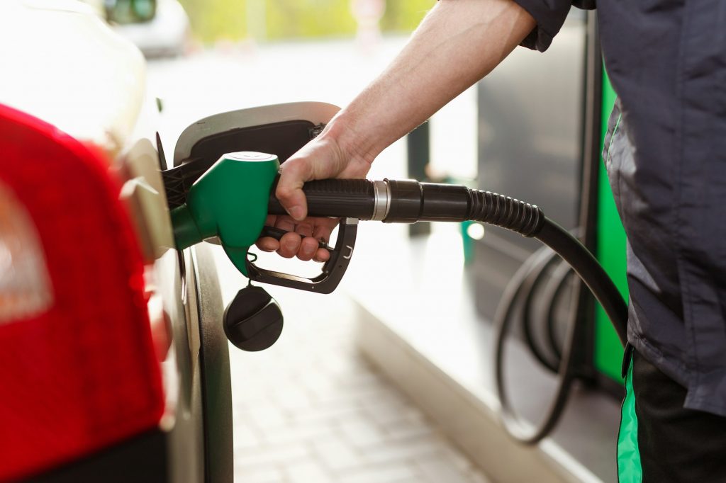 Crop guy filling car with fuel